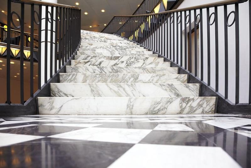 A polished Guangxi White marble slab standing in the yard, white with grey directional veins